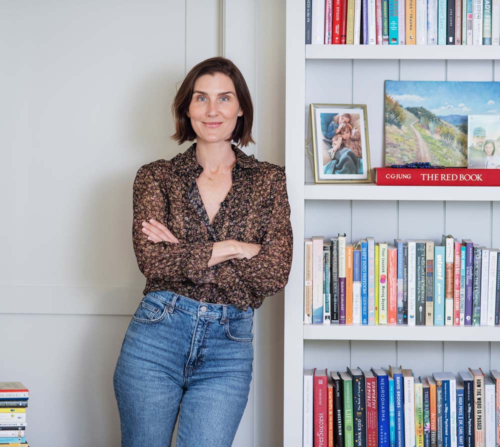 Kasey Crown next to her bookcase